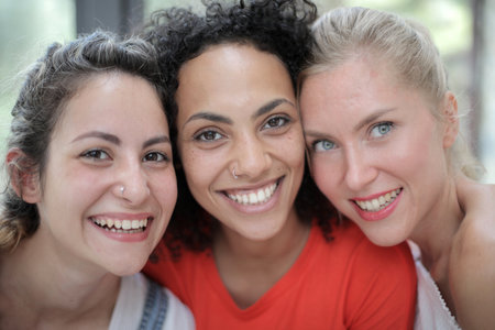A group of friends smiling while taking pictures and sitting indoorsの写真素材