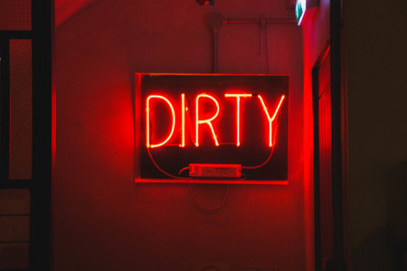 A closeup shot of a red neon light sign  with the text [dirty]の写真素材
