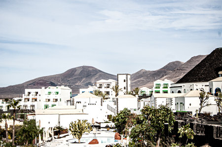 A horizontal shot of a beautiful resort town with white buildings in Lanzarote, Spain on a sunny dayの写真素材