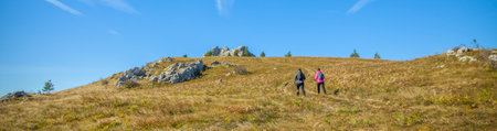 A lovely tourist couple climbing  the Slovenian rocky mountains under the blue skyの写真素材