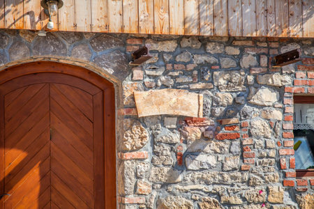 A closeup of a stonewall of a building with a wooden doorの写真素材