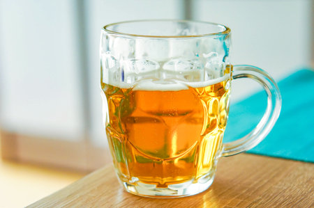 A closeup shot of a glass of beer on a wooden tableの写真素材