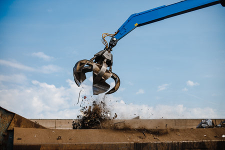 A claw crane grabbing the scrap at a rubbish dump
