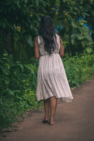 A vertical shot of the lifestyle of an Asian female dressed in whiteの写真素材