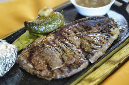 A closeup of steaks with beans, jalapeno, nopal, and roasted potatoの写真素材