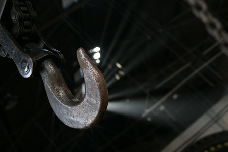 A selective focus shot of a hook and chains captured inside an industrial factory