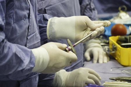 A closeup shot of a spinal surgeon holding a tool during the surgery under the lights - surgical conceptの写真素材