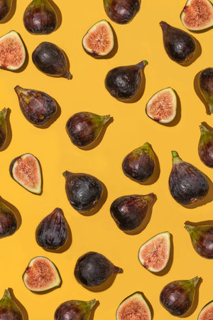 A vertical high angle shot of some delicious and fresh figs on a yellow background