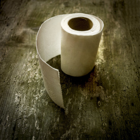 A closeup shot of roll of toilet paper on wooden backgroundの写真素材