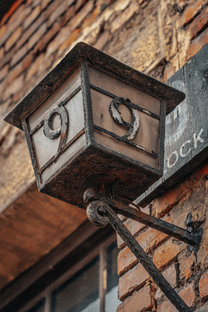 A low angle vertical shot of an old wall lamp with a block number nineの写真素材