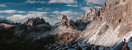 An aerial shot of the breathtaking Cardini di Misurina mountains covered in snow and gleaming under the cloudy skyの写真素材