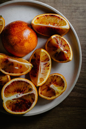 A vertical overhead shot of slices of grapefruits on a white plateの写真素材