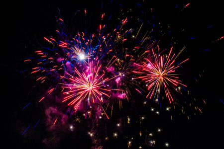 Many multicolored fireworks exploding in the sky at night
