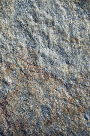 A vertical shot of a textured rugged stone with multi tones of colorの写真素材