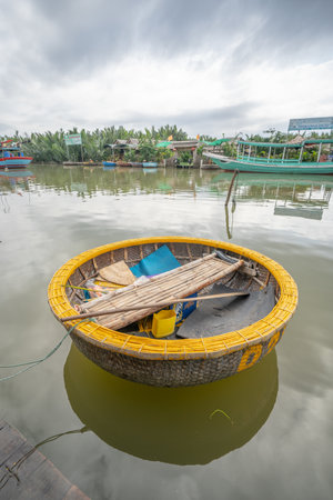 A vertical shot of a Vietnamese round boat in the lake