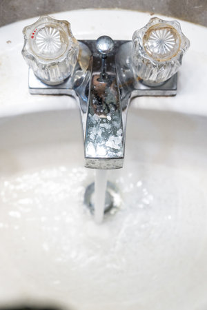 A closeup shot of water flowing from the faucet in the sinkの写真素材