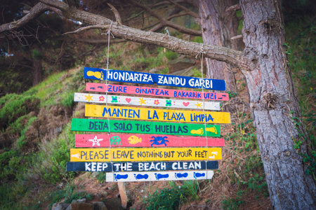 A horizontal shot of a sign at the entrance to the Arribolas beach, in the Basque Country, written in Spanish, English, and Basque languagesの写真素材