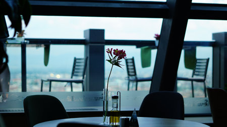 A closeup shot of an empty restaurant with a balcony view on the background