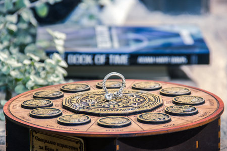 A shallow focus closeup shot of a skull septum piecing on an astrological calendarの写真素材