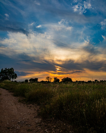A beautiful landscape gleaming under the cloudy sky and the breathtaking, golden sunsetの写真素材