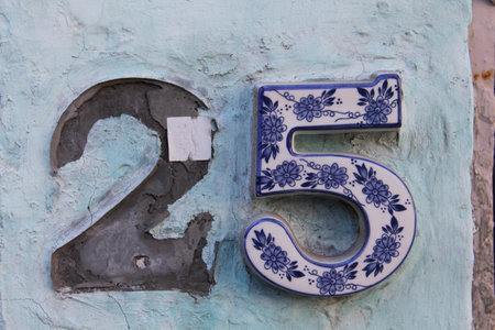 An old house number on the blue wall twenty five