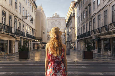 A young female in a floral dress walking around the Commerce Square in Lisbon, Portugalの写真素材