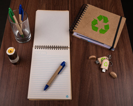 A high angle view of eco pens, notepads and a USB flash drive on the table - environmental conceptの写真素材