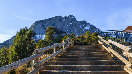 A mesmerizing shot of stairs leading to a park in front of mountains