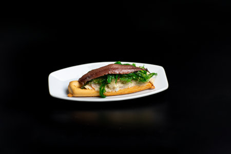 Marinera Marinerica typical spanish tapa from Murcia. Russian salad over bread with a anchovy slice.