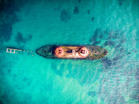 An aerial view of a blue sea and a boat