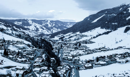 An aerial shot of a snowboarding resort in the snow under the sunlight