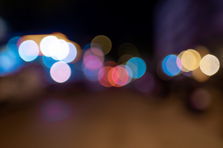 A blurred shot of many colorful lights glowing in the street at night