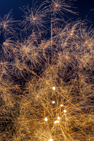 A vertical shot of beautiful golden fireworks in the night sky