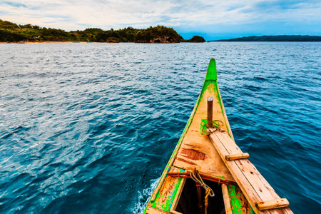 A beautiful view of calm water and ashore captured from a small wooden boat