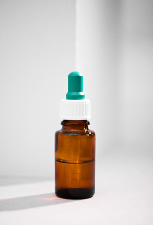 A closeup of medicine bottle with dropper over a white background. Vaccine, medicine, protection, COVID19, coronavirus conceptの写真素材