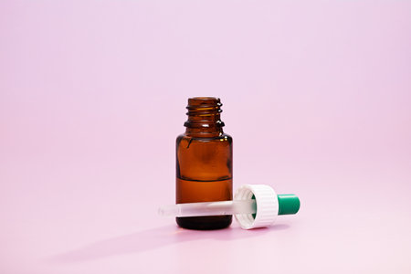 A closeup of medicine bottle and dropper over a pink background. Vaccine, medicine, protection, COVID19, coronavirus conceptの写真素材