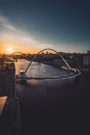 A vertical view of a bridge over a river at sunset in Newcastle Upon Tyne, Englandの写真素材