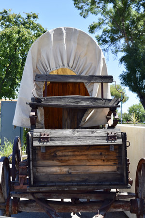 A vertical shot of an old wooden wagon covered with white fabric