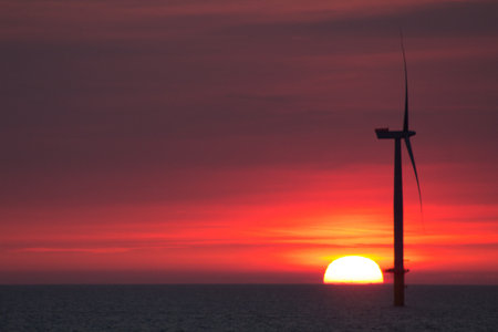 A beautiful view of a wind generator in a sea at the sunsetの写真素材