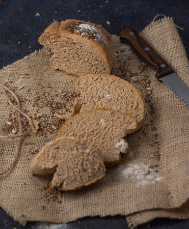 The delicious, crusty sliced bread on a fabric with a knife