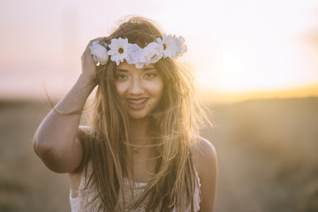 A beautiful brunette woman wearing a flower headband, smiling and looking at the cameraの写真素材