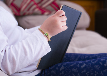 A closeup shot of a seated baby reading a book