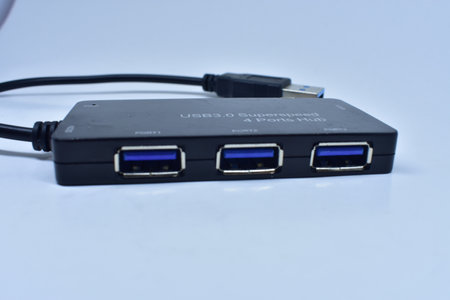 A closeup of a black portable USB hub with a wire isolated on white backgroundの写真素材