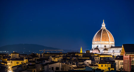 An aerial shot of the Cathedral of Santa Maria del Fiore and the buildings in Florence, Italy at nightの写真素材
