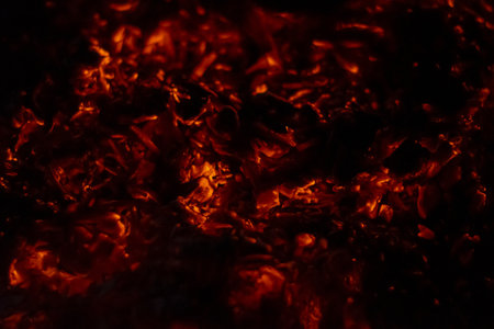 A closeup of embers of a burning log creating a fiery backgroundの写真素材