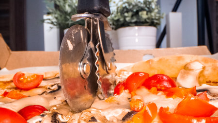 A closeup of a pizza slicing processの写真素材