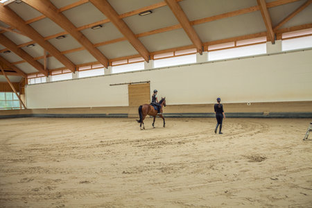 A Slovenian girl riding a horse in an equestrian arenaの写真素材