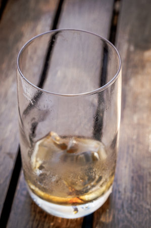 A vertical selective focus shot of an empty glass on wooden tableの写真素材