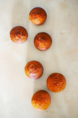 An overhead shot of muffins on the table under the lights