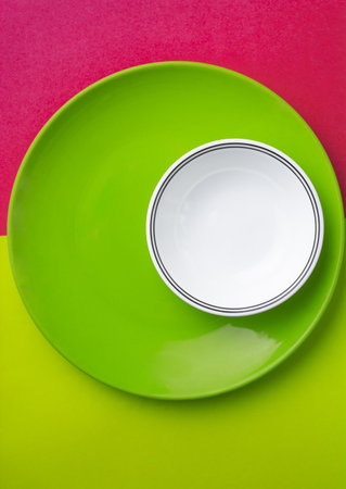 A vertical shot of a white small plate on a big green plate